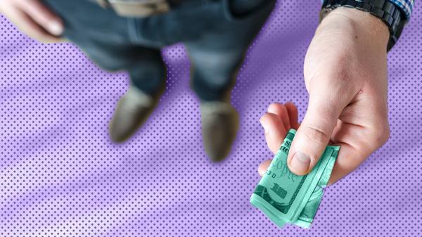 A man holding a ten-dollar bill